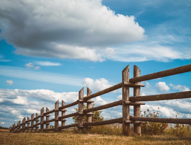 wooden rustic fence in village and blue sky with clouds greeley co